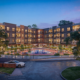 real-time 3D rendering USA of modern residential courtyard with central swimming pool, apartment buildings, landscaped seating, and outdoor amenities