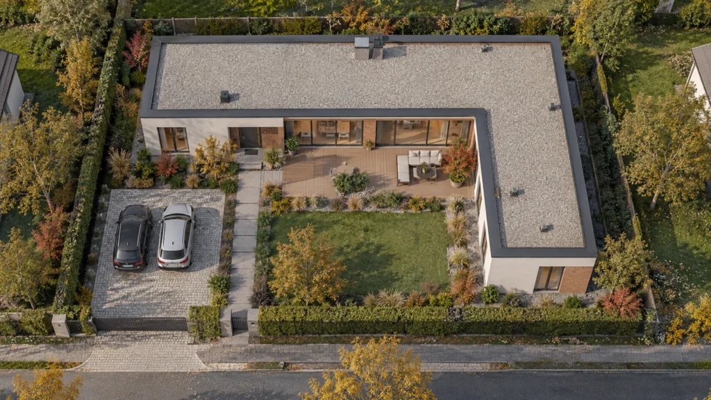 Yantram Studioโs Warsaw aerial architectural rendering shows a single-storey L-shaped villa around a timber terrace, lawn and two-space driveway. โ Architectural Visualization Company In Warsaw